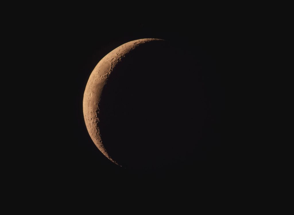 Close-up view of the crescent moon showcasing detailed lunar surface texture and craters.
